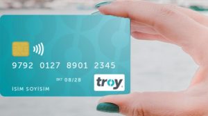 A conceptual illustration showing a judge's gavel entangled in digital payment networks like Visa and Mastercard, with the Turkish TROY logo emerging as a bright, secure alternative.