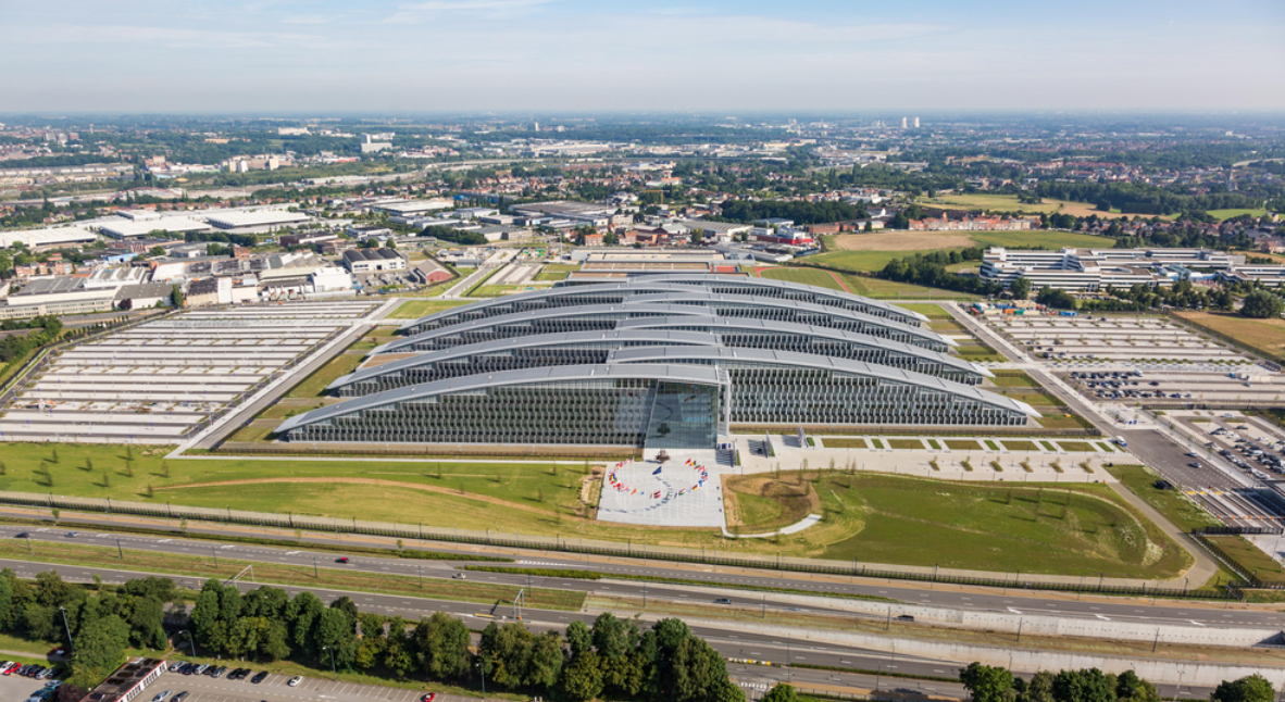 Exterior view of NATO's SHAPE headquarters in Belgium with flags of member nations, visualizing the location of the recent espionage arrest.