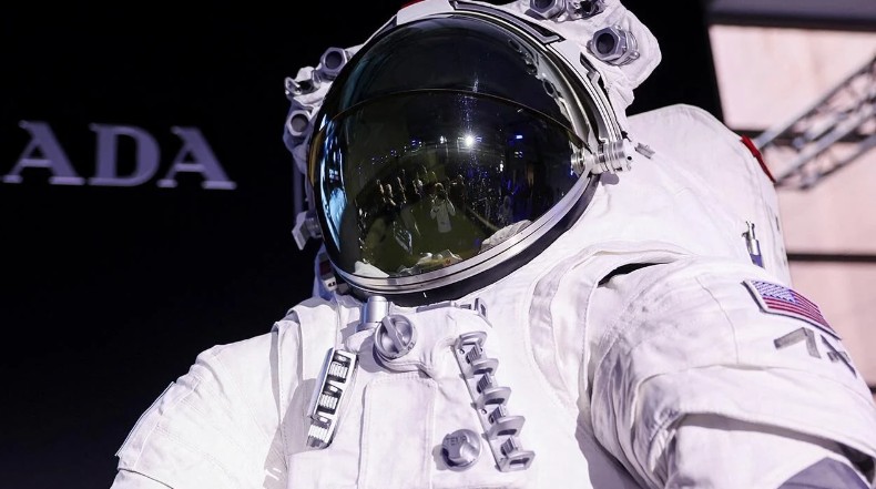 An astronaut wearing a prototype of the next-generation Axiom lunar spacesuit, standing against a dark backdrop, symbolizing the delayed Artemis missions.