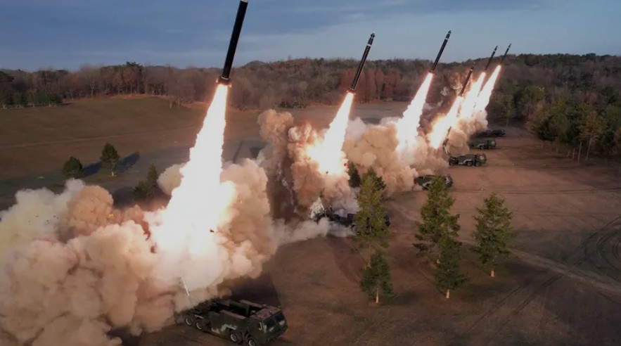 A side-by-side technical cross-section comparing an unguided artillery rocket and a precision-guided missile, highlighting the missile's internal guidance computer and seeker head.